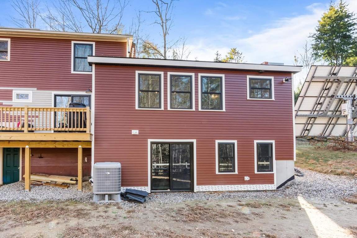 New two-story rear addition with black-trimmed windows and walkout slider
