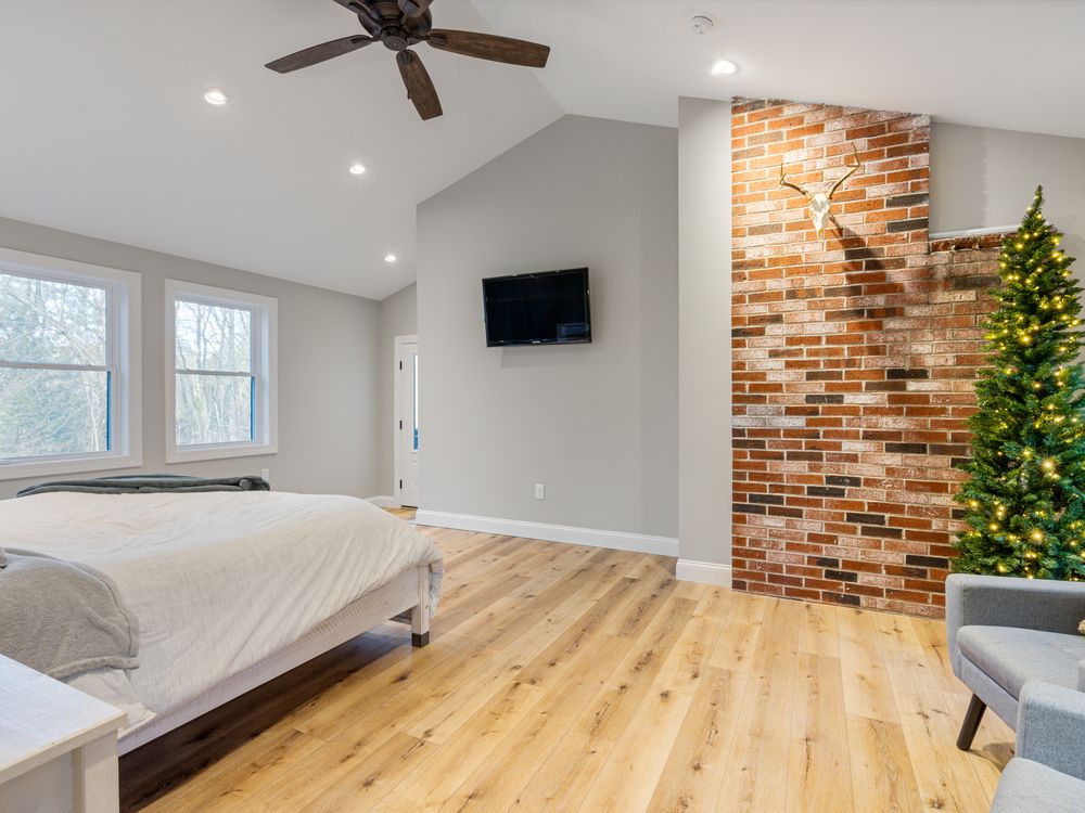 Bedroom with exposed brick chimney and hardwood floors