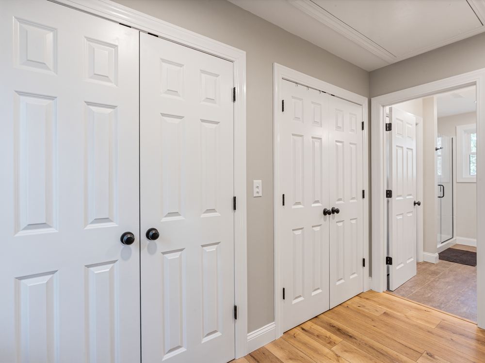 Upstairs hall with new six-panel closet doors and wide-plank flooring