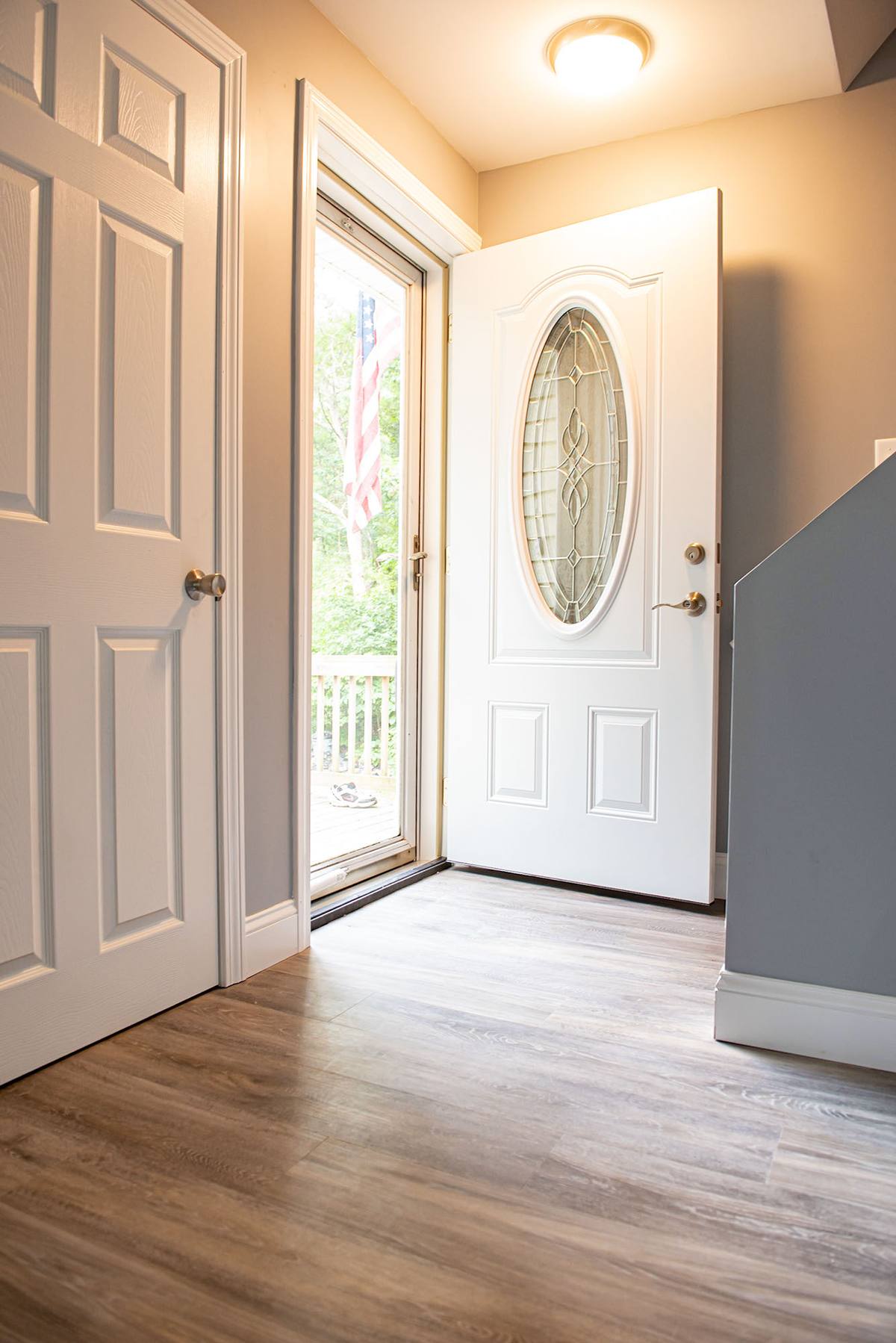 Restored entry with new door, trim and plank flooring