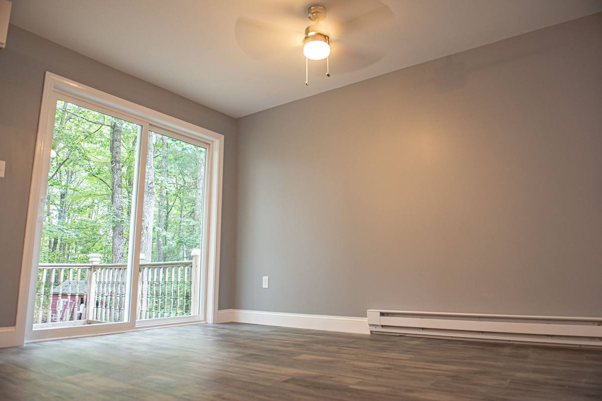 The same room finished, with a new slider to the deck and plank flooring