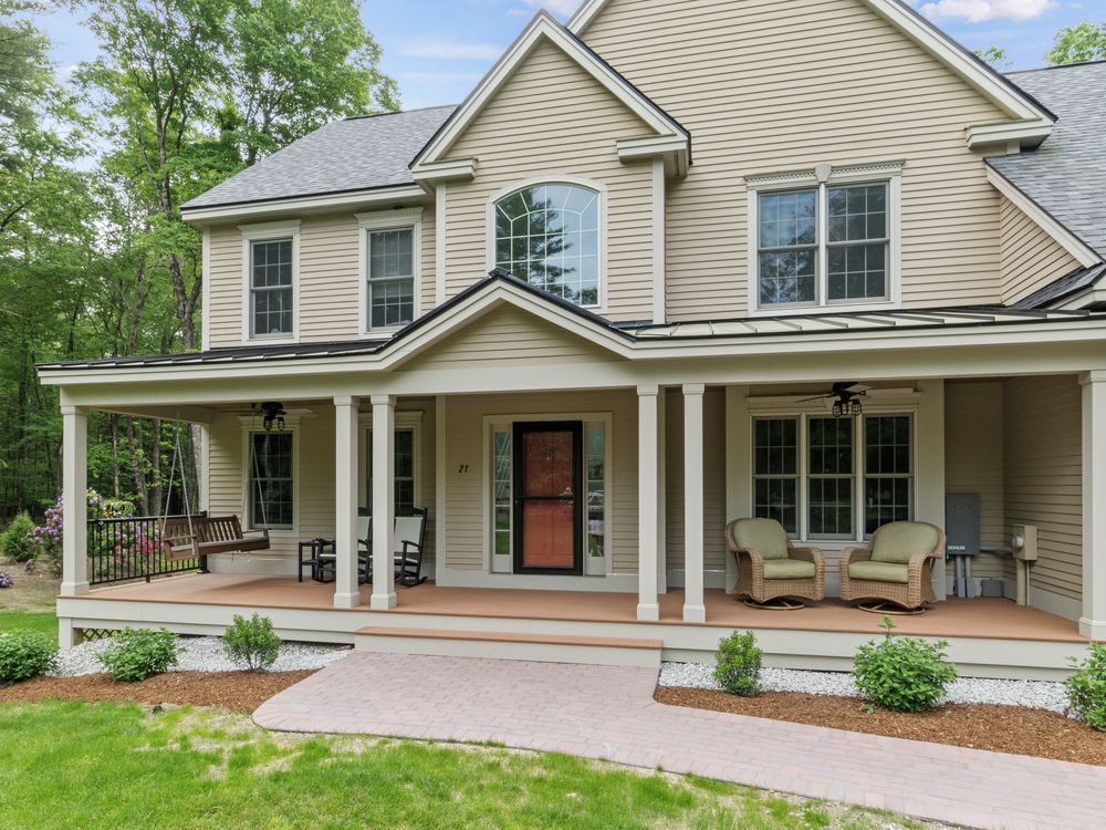 The finished porch wrapping the entry, with columns, brick walk and plantings