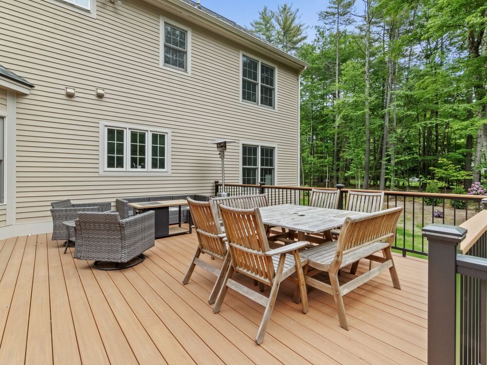 Deck dining and lounge areas looking out into the woods