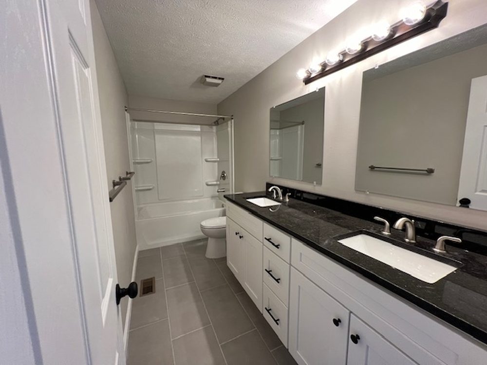 Finished bath with double vanity and tiled floor