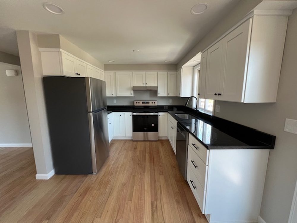 New kitchen with shaker cabinetry and hardwood floors