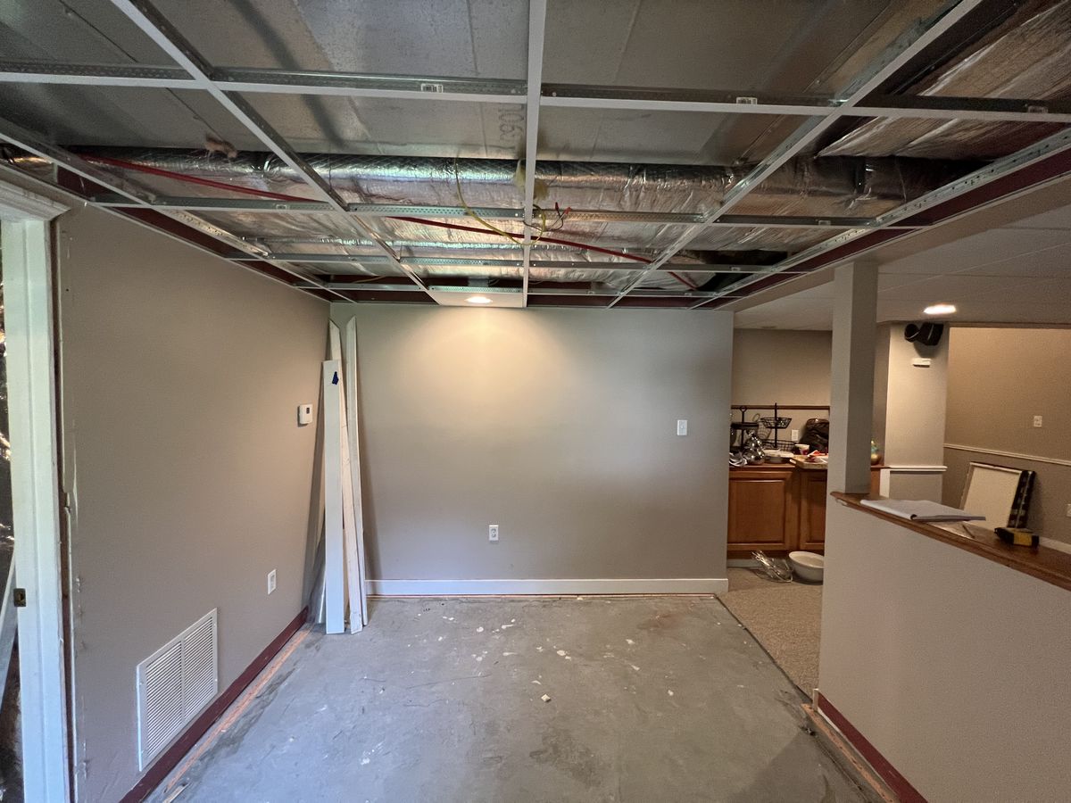 Lower level stripped back after water damage, ceiling grid and slab exposed