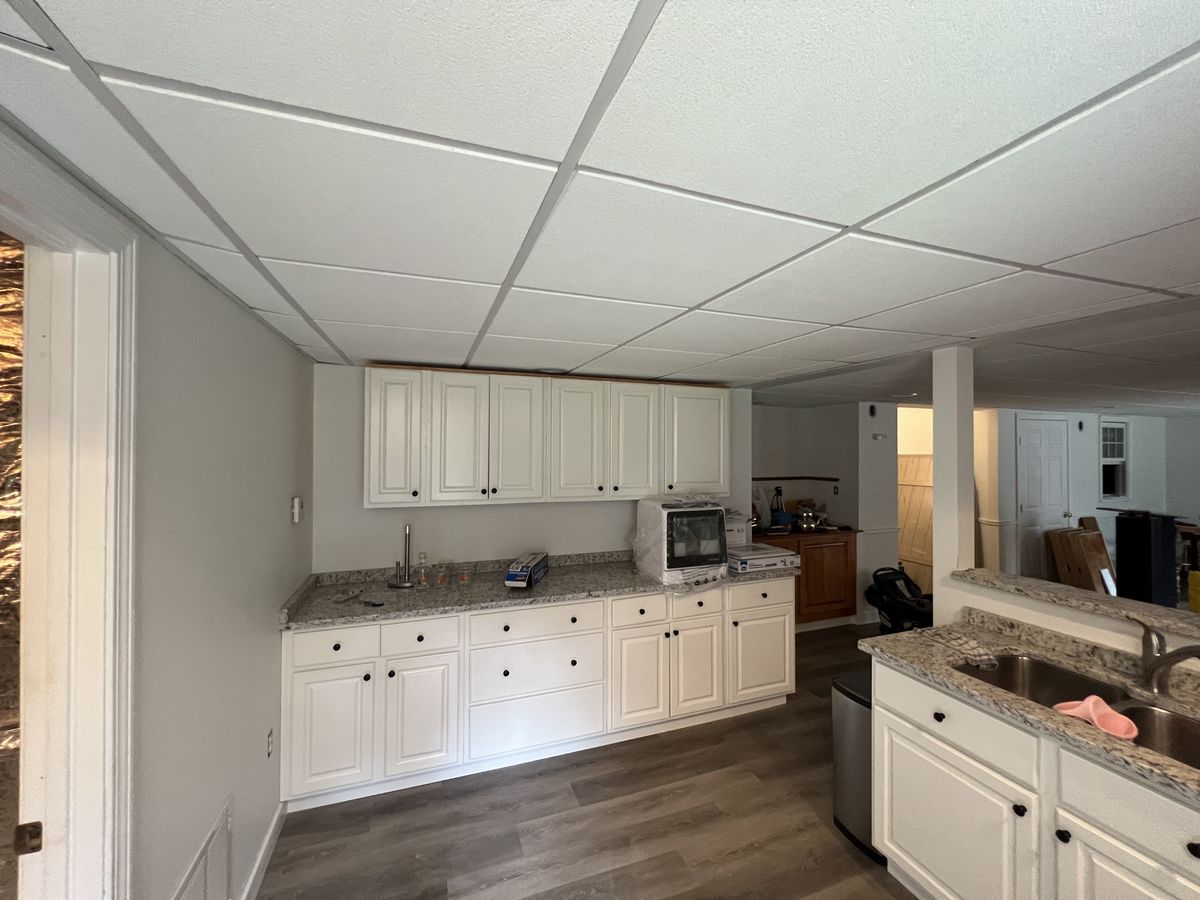 Finished lower level with new cabinetry, granite counters and plank flooring